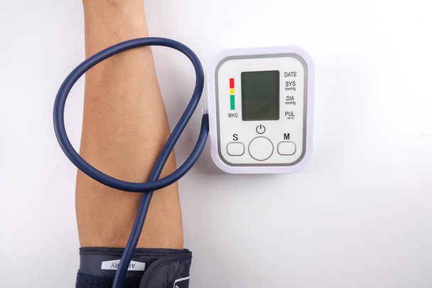Mannelijke controleren bloeddruk op witte achtergrond - Foto, afbeelding