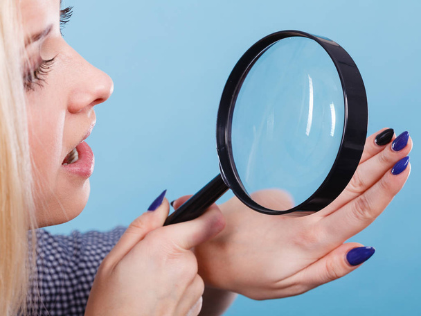 Woman looking at nails through magnifying glass - Foto, Imagem