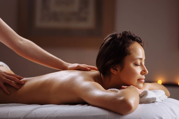 Beautiful woman receiving a relaxing back massage at spa. - Zdjęcie, obraz