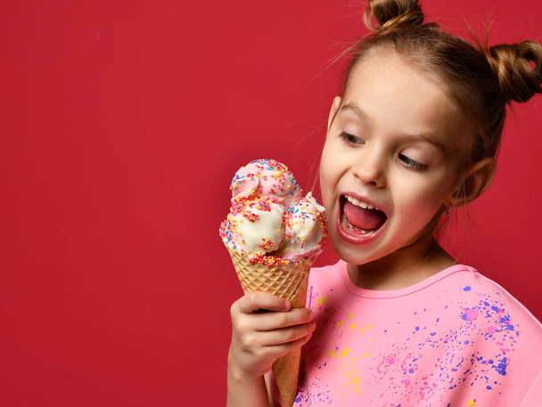 Pretty baby girl kid eating licking big ice cream in waffles cone with raspberry happy laughing - Photo, image