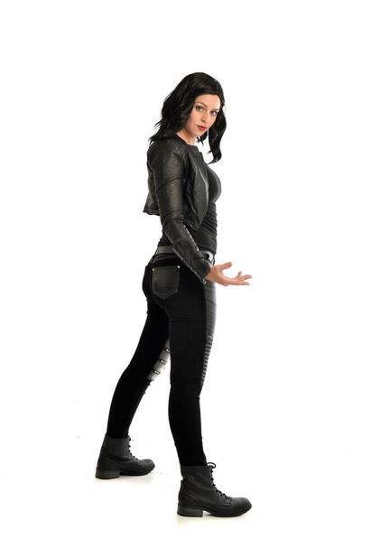 full length portrait of black haired girl wearing leather outfit. standing pose on a white background. - Zdjęcie, obraz