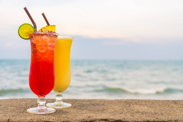 Iced cocktails drinken van glas met zee en strand achtergrond - Foto, afbeelding