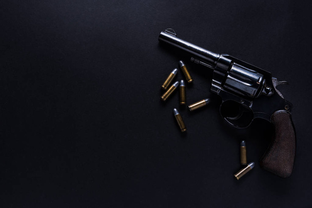 pistola con balas sobre fondo negro
 - Foto, Imagen