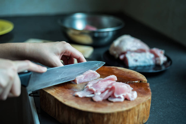 female cook cutting pork on kitchen - Фото, изображение