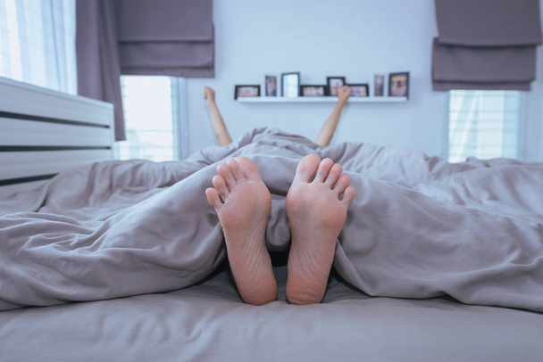 Close up of  barefoot,Feet and stretch lazily on the bed after waking up - Φωτογραφία, εικόνα