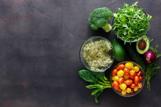 Set of ingredients for detox salad. Broccoli, spinach, avocado, arugula, pea shoots, alfalfa, onion, cherry tomatoes and cucumber on grey, top view - Zdjęcie, obraz