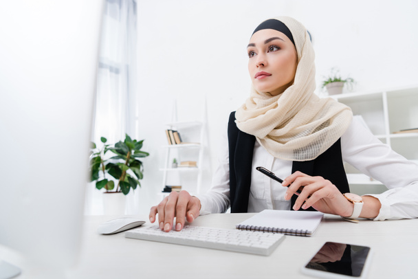 Portret van gerichte Arabische zakenvrouw werken op de computer in kantoor - Foto, afbeelding