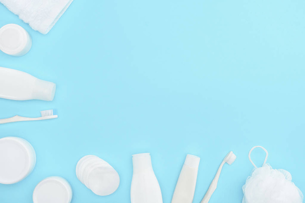 sfondo minimalista con lozione in bottiglia, crema in contenitori, spazzolini da denti, tamponi di spugna e cotone, isolato su blu
 - Foto, immagini