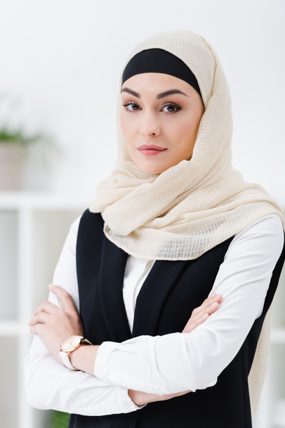 ritratto di donna d'affari araba in hijab con le braccia incrociate in piedi in ufficio
 - Foto, immagini