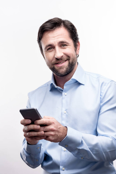 Upbeat middle-aged man texting his family - 写真・画像