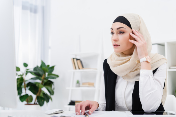 pensive arabic businesswoman sitting at workplace in office - 写真・画像