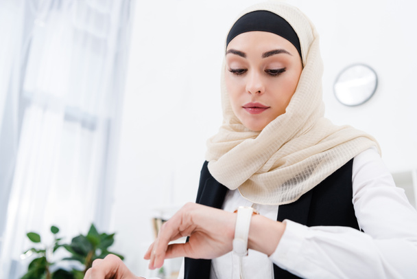 portrait of businesswoman in hijab checking time in office - Fotoğraf, Görsel