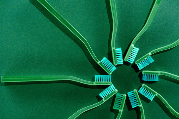 vista superior de la composición del círculo con cepillos de dientes verdes en verde
 - Foto, Imagen