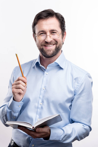 Upbeat professor posing with notebook and pencil - Фото, изображение