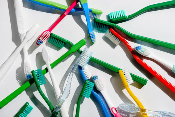 fondo con cepillos de dientes de colores para la higiene matutina, en blanco
 - Foto, imagen