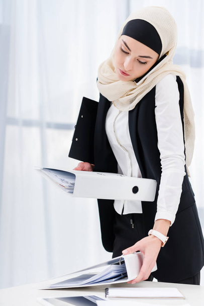 portret interesu w hidżab z dokumentów, rozmowy na smartfonie w biurze - Zdjęcie, obraz
