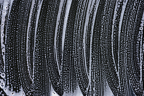 vista superior de espuma de jabón blanco en la superficie negra
 - Foto, Imagen