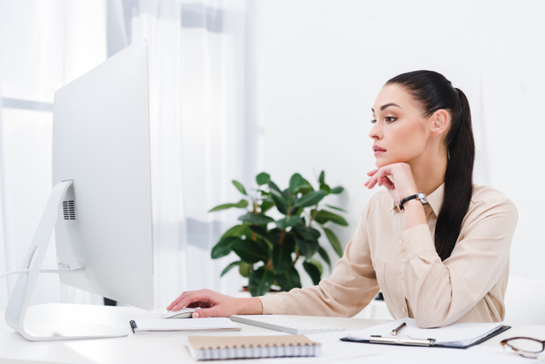 side view of concentrated businesswoman working on computer in office - Photo, Image
