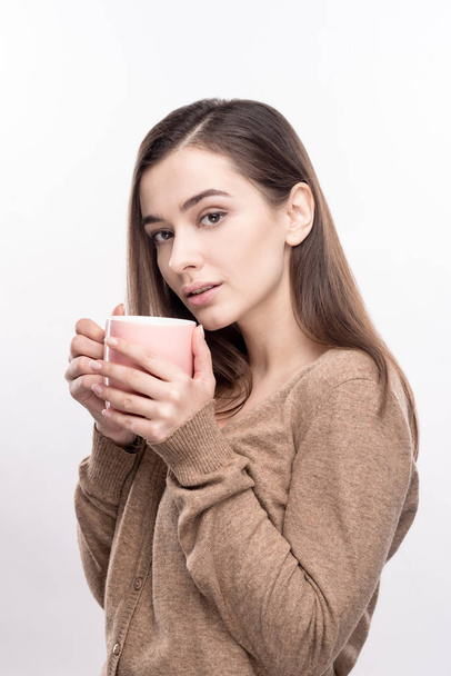 Tender young woman posing with coffee mug - Foto, imagen