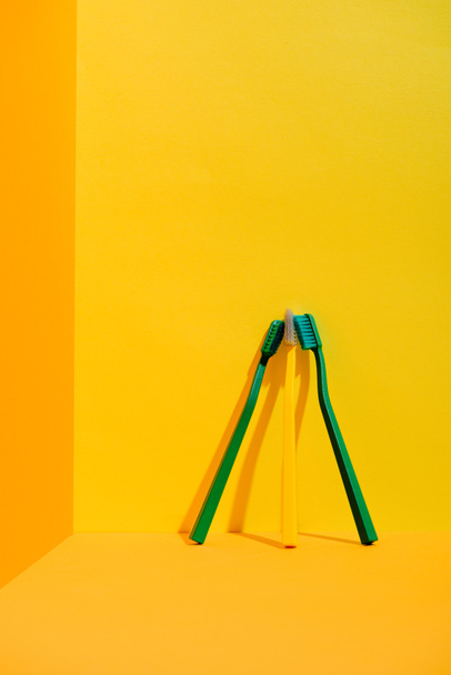 spazzolini da denti verdi e gialli a parete arancione
 - Foto, immagini