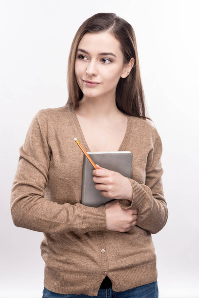 Cheerful woman pressing notebook to her chest - Photo, image