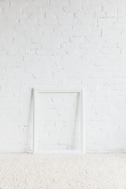 marco vacío delante de la pared de ladrillo blanco, concepto de maqueta
 - Foto, imagen