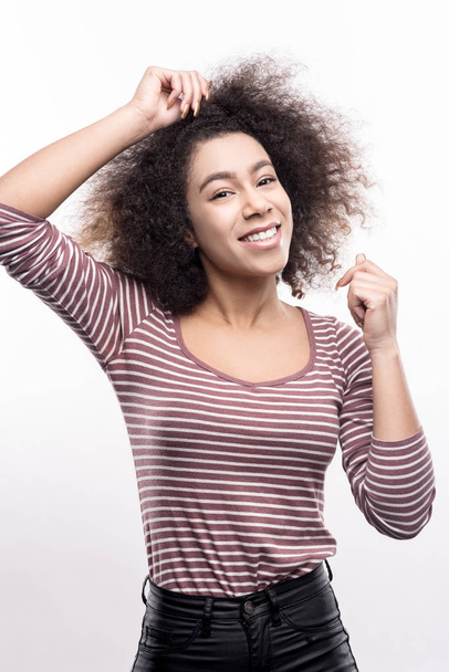 Beautiful woman touching her curly hair while posing - Фото, зображення