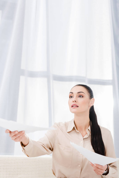 portrait of businesswoman outstretching hand with documents in office - Foto, Bild