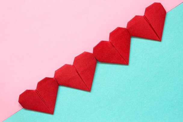 Red origami srdce na růžové a modré pozadí. Obrázek pro dárkovou kartu pro den Valentýna. - Fotografie, Obrázek