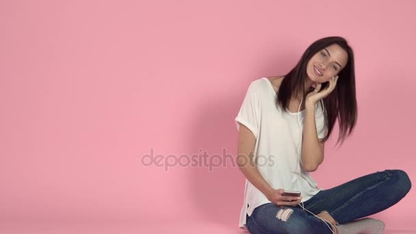 Young woman listening music through headphone - Video