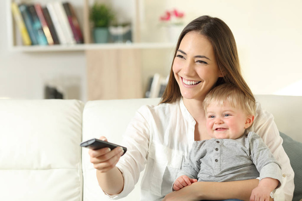 Happy mother and baby watching tv at home - Photo, image