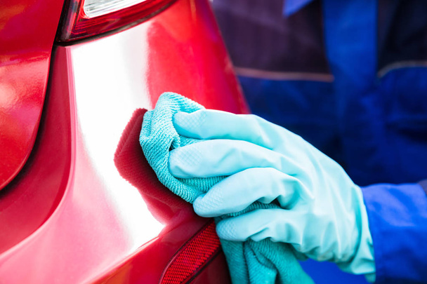 Young Happy Male Worker Cleaning Red Car With Cloth - Photo, Image