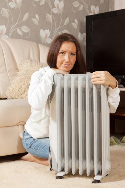 woman near warm radiator in home - Foto, afbeelding