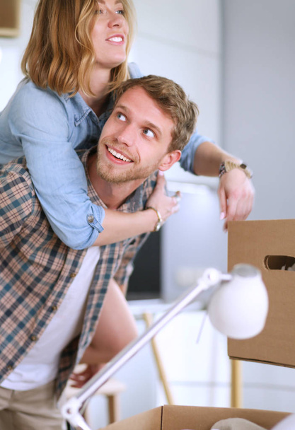Couple unpacking cardboard boxes in their new home. Young couple. - Zdjęcie, obraz