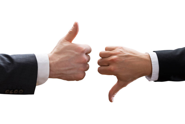 Close-up Of Two Businesspeople Hands Showing Thumb Up And Thumb Down Sign Over White Background - Photo, Image