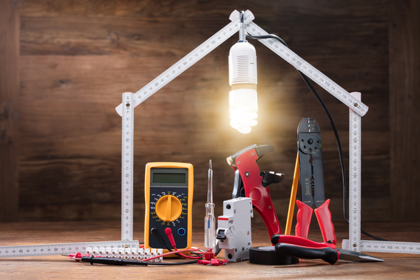 Naprawa narzędzia pod oświetlony dom z miara zwijana na drewnianym stole - Zdjęcie, obraz