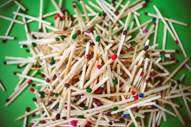 stack of wooden multicolored matches on green background, top view. - Photo, Image