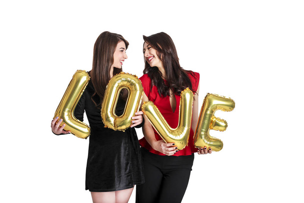 Same sex love concept. Two beautiful females women girls from lgbt community with long gorgeous hair on February 14th Happy valentine's love photo shoot, having fun, making faces, air kiss kissing. - Foto, imagen