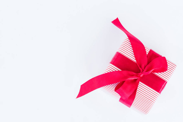 Una caja de regalo con cinta roja sobre fondo blanco.. Vacaciones, presente, navidad y concepto de felicidad
. - Foto, Imagen