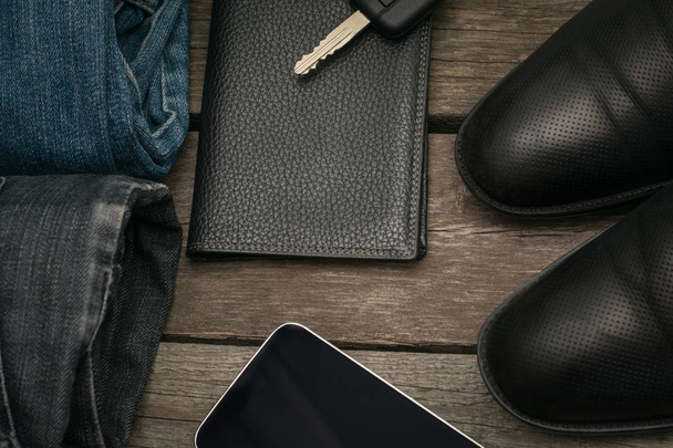 Male set for day from wallet, jeans and car key on wooden board. Flat lay. - Foto, Imagem