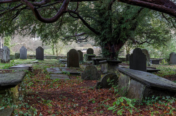 Un patio histórico cubierto de tumbas en el norte de Gales con algunas piedras en la cabeza de pizarra
 - Foto, Imagen