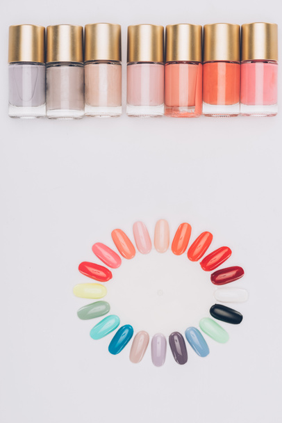 top view of row of nail polishes and palette isolated on white - Photo, Image