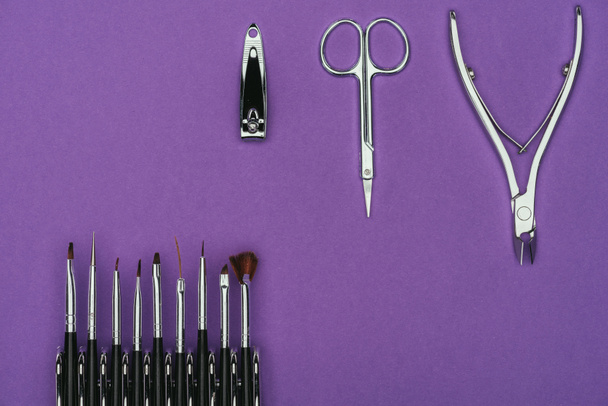top view of brushes and manicure tools isolated on purple - Photo, Image