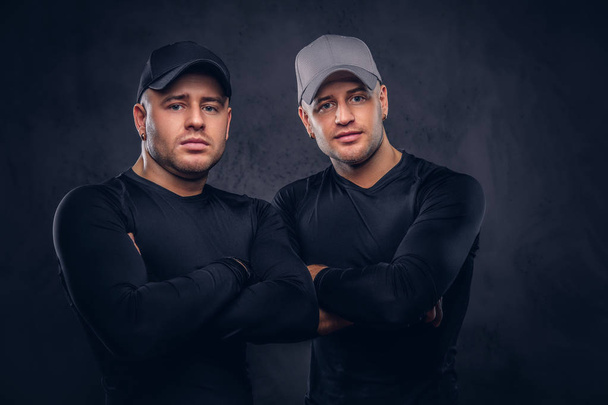 Portrait de deux beaux jeunes hommes vêtus d'un sportswea noir
 - Photo, image