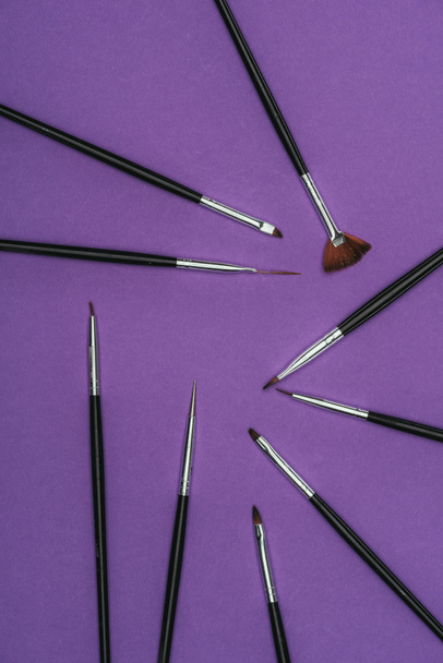 top view of scattered brushes isolated on purple - Fotografie, Obrázek