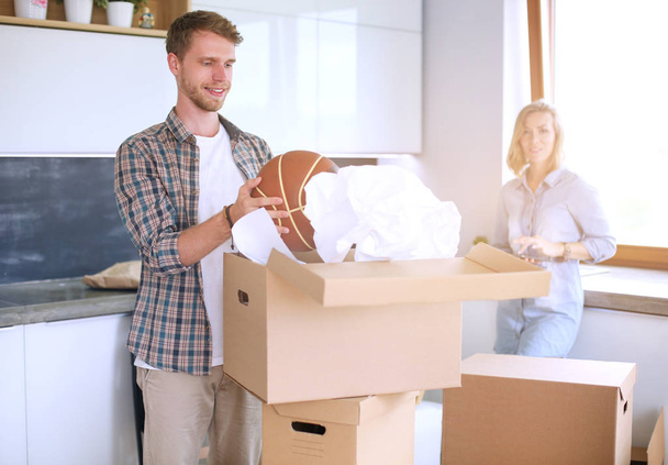 Couple unpacking cardboard boxes in their new home. Young couple. - Photo, image
