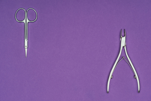 top view of scissors and nail nippers isolated on purple - Photo, Image