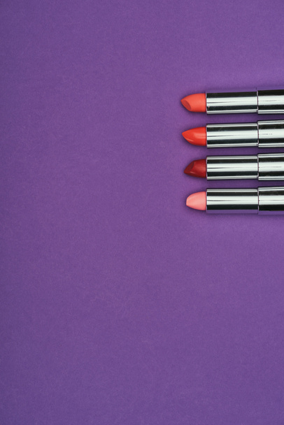 top view of red and pink lipsticks isolated on purple - Photo, Image