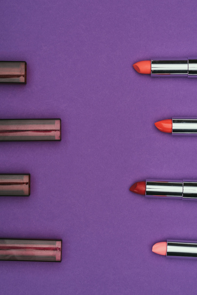 top view of colored lipsticks isolated on purple - Zdjęcie, obraz