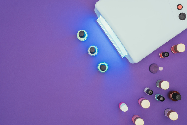 верхний вид ультрафиолетового света лампы и лака для ногтей
  - Фото, изображение